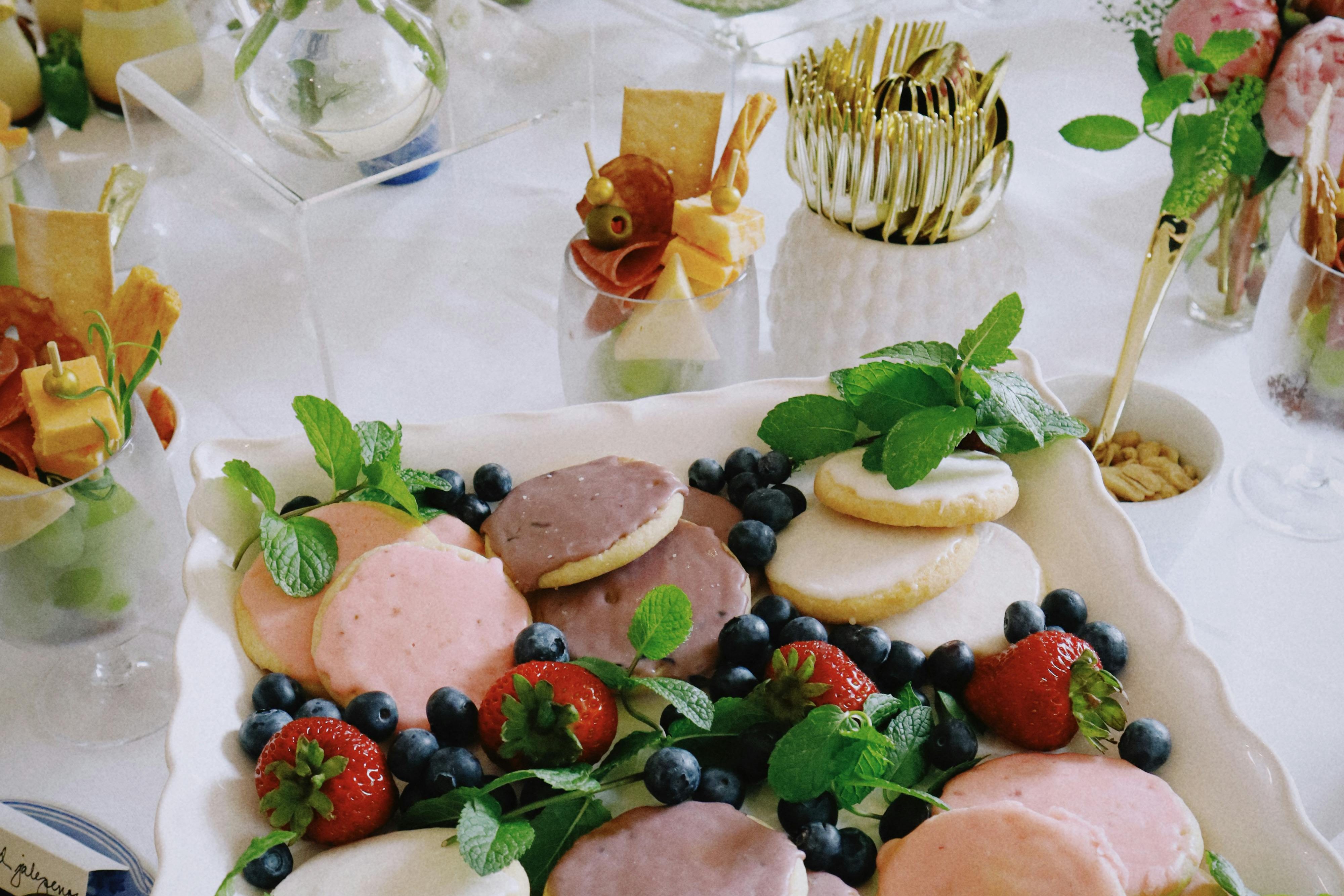A lavish spring-inspired dessert table featuring pastel-glazed cookies, fresh berries, and vibrant floral arrangements, perfect for AI-powered entertaining and chic at-home gatherings.